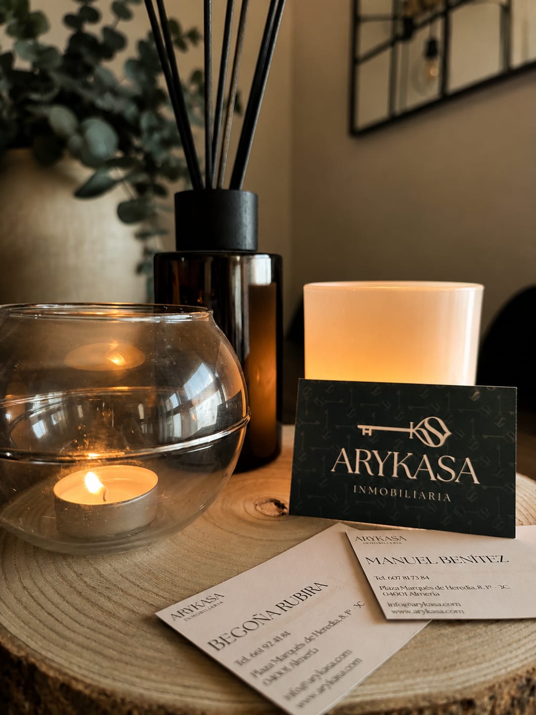 Tarjetas de visita de Arykasa junto a una vela encendida